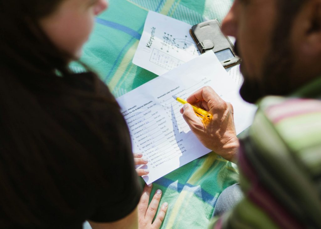 Un homme et une femme de dos travaillant sur une feuille